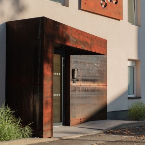 Minimalistický vstupní rám v cortenu jako kontrastní architektonický prvek. Ukázka využití cortenu v rezidenční architektuře.